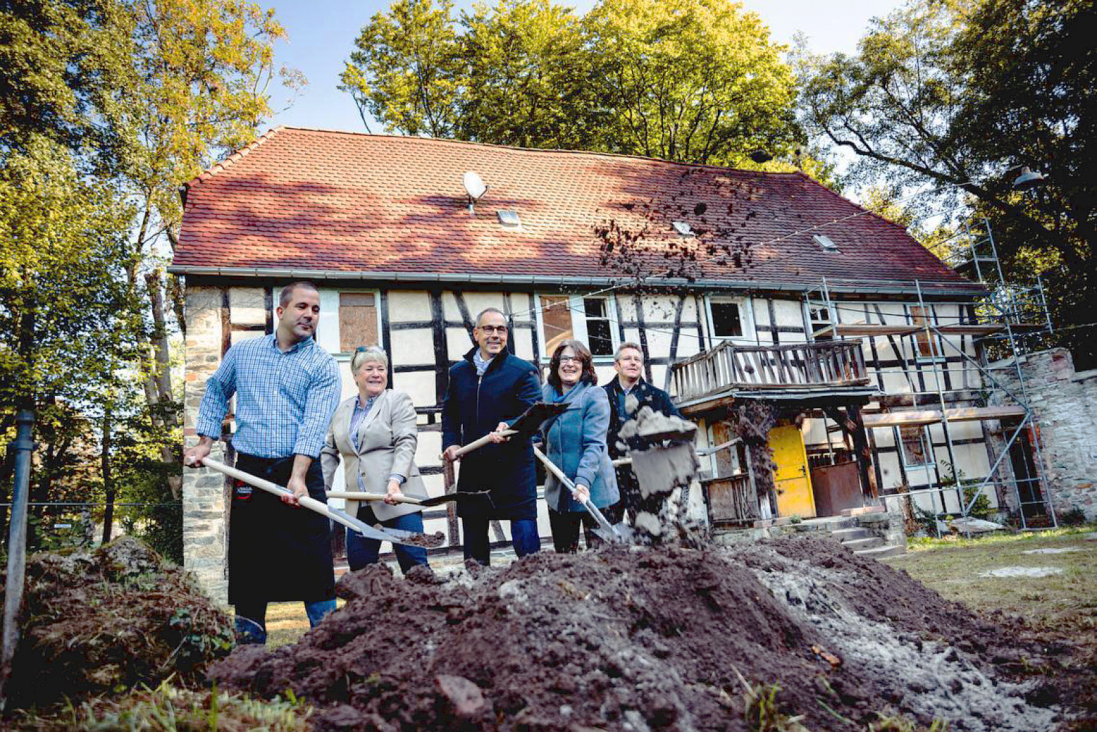 Spatenstich vor dem Haupthaus der Alten Mühle mit den vier Protagonisten vor einem Erdhaufen