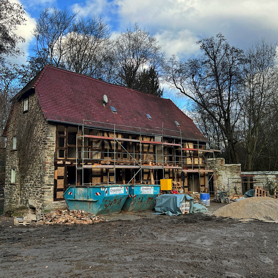 Haupthaus mit Gerüst und Containern davor