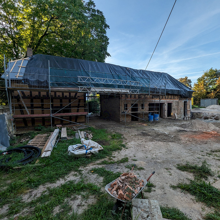 Scheunenhaus mit Gerüst und Folienabdeckung, Blick vom Hof