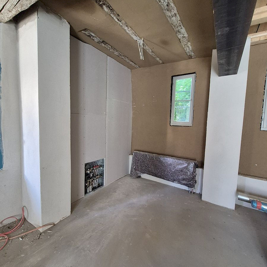 Verputzte Wände und Boden im Haupthaus, Blick auf neue Heizung und Wasseranschlüsse