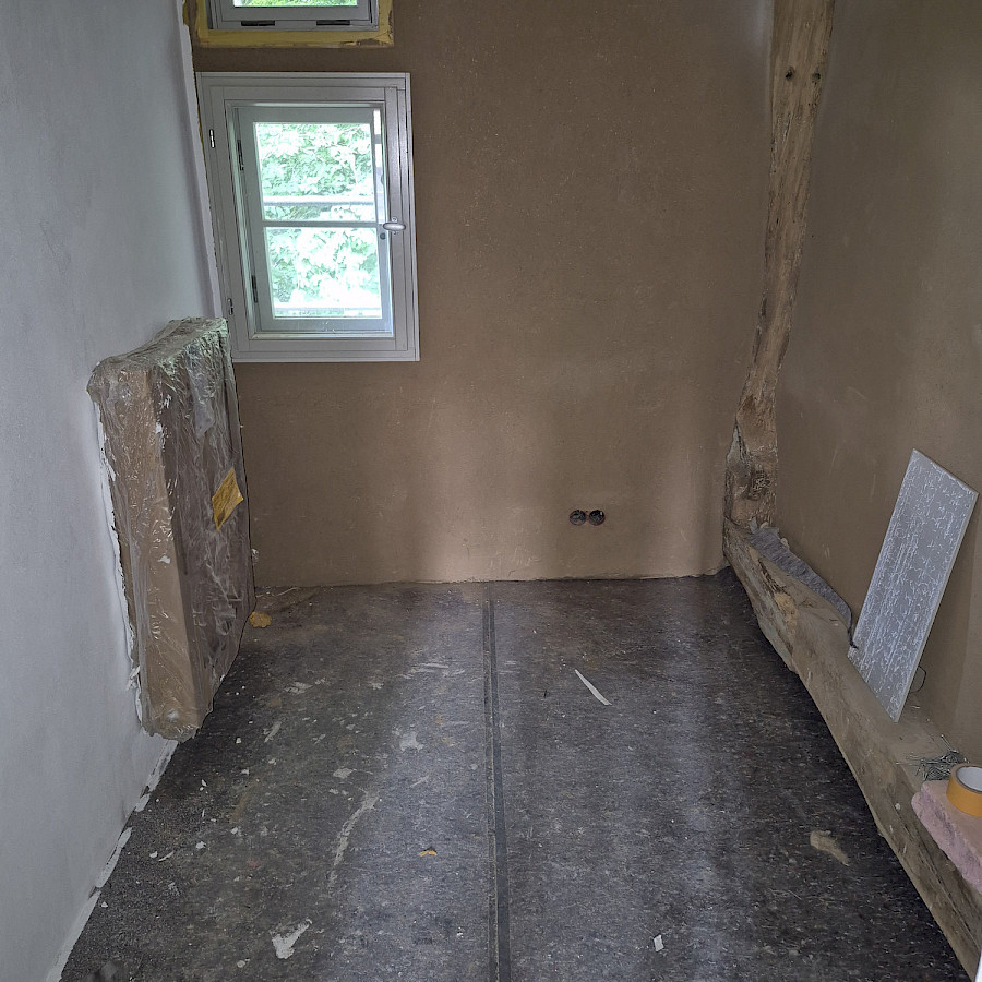 Blick in Raum im Obergeschoss des Haupthauses mit teils verputzten, teils gestrichenen Wänden