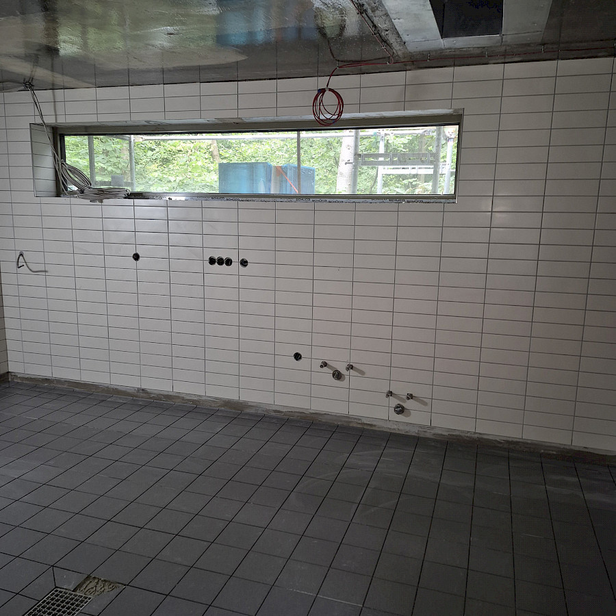 Geflieste Wände und gefliester Boden in der zukünftigen Küche im Zwischenbau